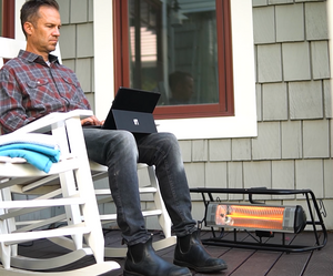 Man using laptop on his porch with a 1500 Watt infrared space heater keeping him warm.
